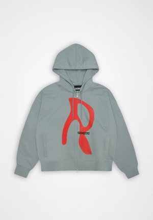Lichtgrijze hoodie met rits, met een grote rode abstracte "R" en de cijfers "13042012" op de voorkant, voorzien van een capuchon en zijzakken.