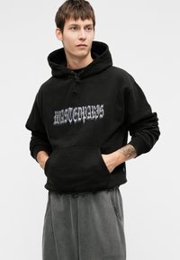 Melna kapuce ar priekšējo kabatu, regulējamu šņoru uzsistīšanai, un baltu "WASTEDPARIS" grafiku gotikas fontā. Mīksts audums, atvieglota piegriezuma.