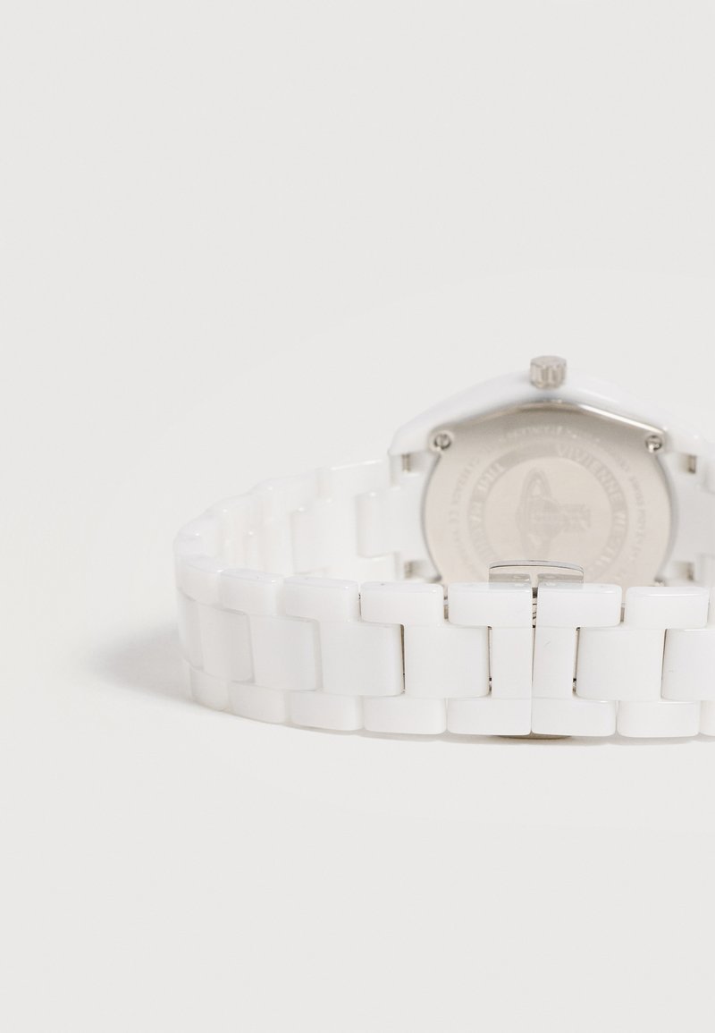 White ceramic watch band with linked rectangular segments and silver clasp, shown from the back with the watch case partially visible.