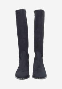 Bottes en daim au-dessus du genou en marine foncé, présentant une texture lisse, un bout arrondi et une fermeture éclair latérale pour un enfilage facile. Semelle plate au design minimaliste.