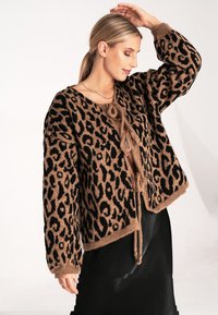 Leopardenmuster-Cardigan in Braun- und Schwarztönen, mit einer Bindeschließe, weichem Strickmaterial und langen Ärmeln mit gerippten Bündchen.
