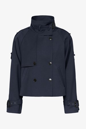 Granatowa krótka kurtka z fakturowanej tkaniny, z podwójnym rzędem guzików, wysokim kołnierzem oraz regulowanymi klamrami na rękawach.