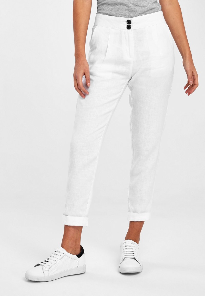 Pantalons en lin blanc avec une coupe décontractée, présentant une taille haute, deux plis à l'avant et des ourlets retournés. Décorés d'accents en bouton noir.