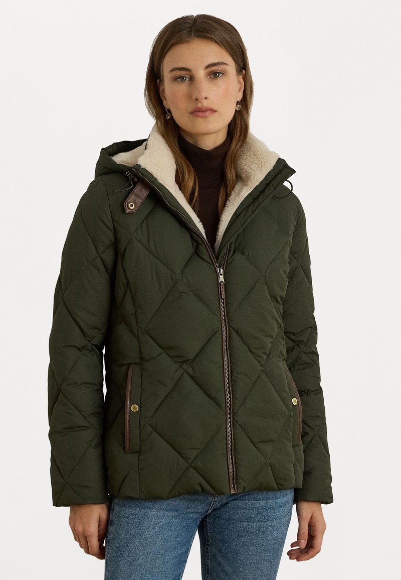 Prešívaná zelená bunda s kapucňou so skombinovaným kožuchom, so zipsom a hnedými akcentmi. Obsahuje bočné vrecká a má priliehavý strih.