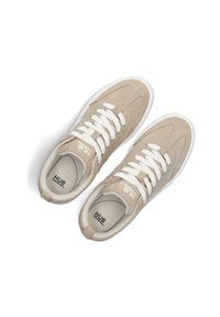 Beige suède sneakers met witte veters, ronde neus, platte zool en een logo op de tong. Soepele textuur met stikdetails.
