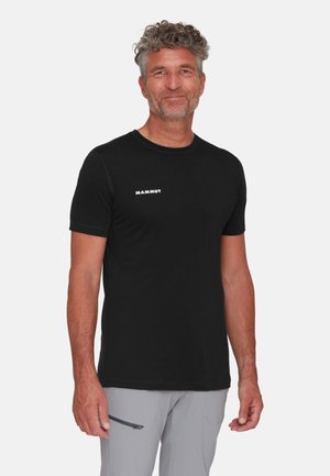 Zwarte T-shirt met korte mouwen gemaakt van zachte stof, met een wit "MAMMUT" logo op de voorkant, aangevuld met contrasterende stiksels en een ronde halslijn.