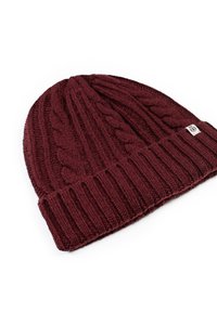 Maroon knitted beanie with cable pattern and ribbed brim. Made from soft material, featuring a small branded patch on the side.