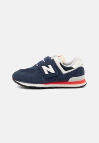 Sneaker blu navy con materiali in camoscio e rete, dettagli bianchi, cinturino in Velcro e suola in gomma nera con un dettaglio rosso a metà suola.