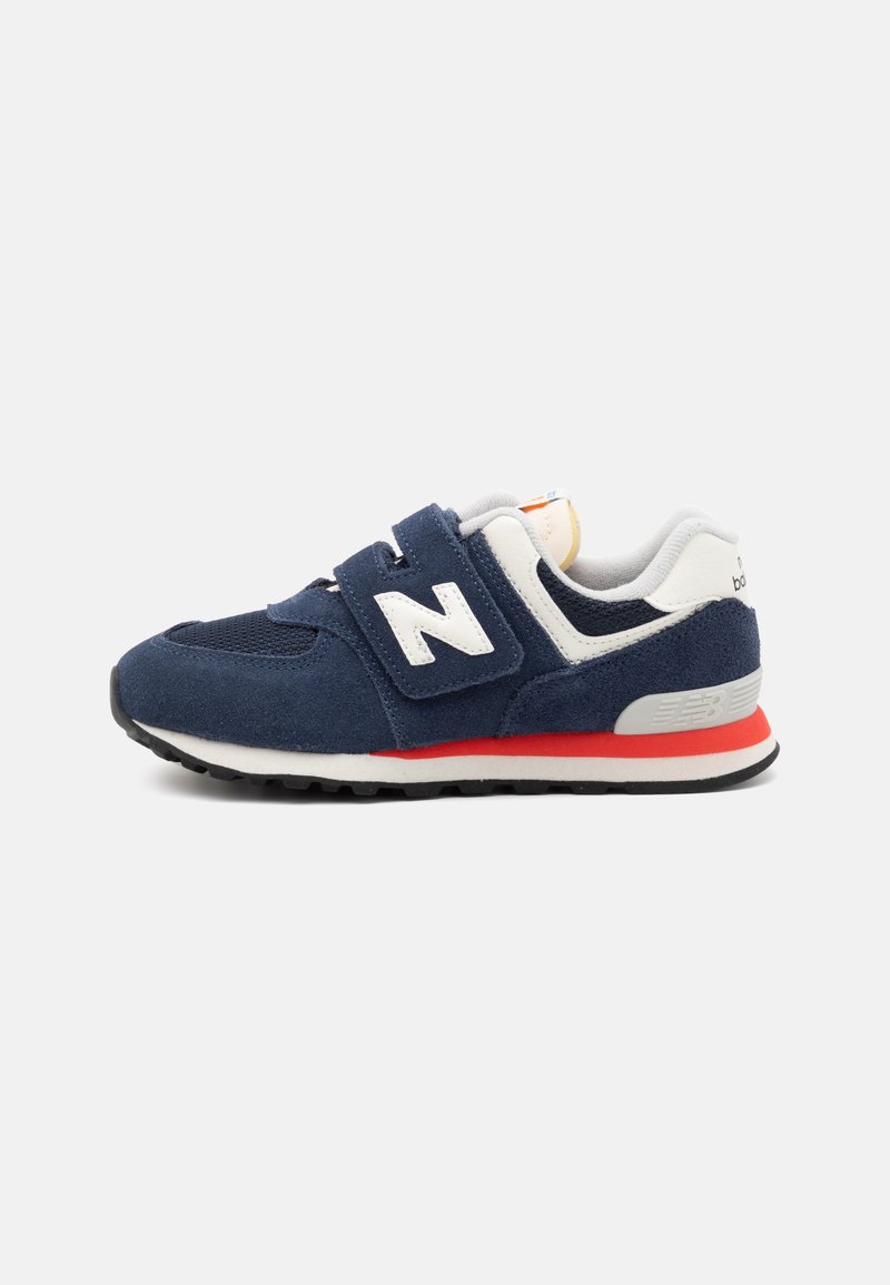 Sneaker blu navy con materiali in camoscio e rete, dettagli bianchi, cinturino in Velcro e suola in gomma nera con un dettaglio rosso a metà suola.