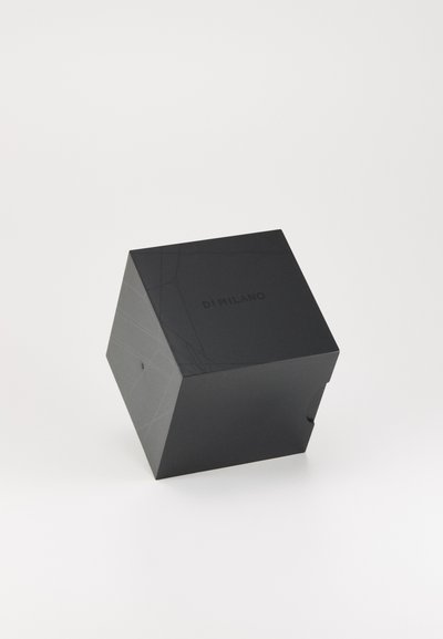 Caja cuadrada negra con un acabado mate, que presenta líneas geométricas sutiles y "DI MILANO" grabado en la parte superior. El diseño plegado incluye una apertura lateral.