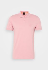 Polo rose clair à manches courtes avec col et deux boutons, avec un petit logo embossé sur la poitrine.