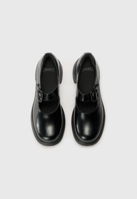Black leather Mary Jane shoes with a round toe, buckle strap, and textured rubber heel, featuring a smooth finish and cushioned insole.