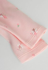 Heleroosa puuvillane kangas, millel on muinasjutuline lille- ja haldjate mustrit. Servadel on õrnade õmbluste detailid.