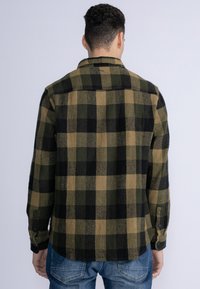 Grün und schwarz karierte Hemd, im Button-up-Stil, gemusterten Stoff, lange Ärmel mit geknöpften Manschetten, gerader Saum, weiche Textur.