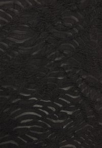 Tecido preto texturizado com um padrão ondulado, feito de material transparente com um brilho subtil e detalhes de costura intrincados.