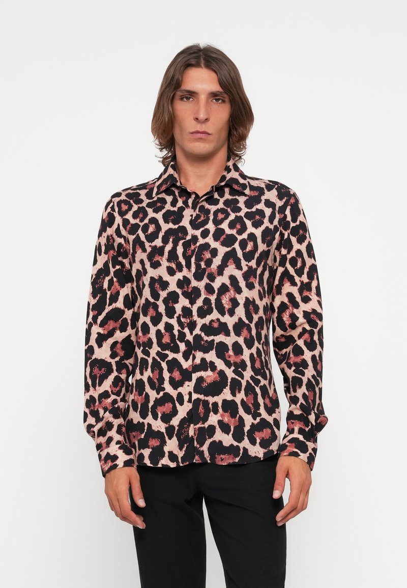 Leopard print shirt in pink and black, featuring a button-up design, long sleeves, and a smooth fabric texture. Worn with black pants.