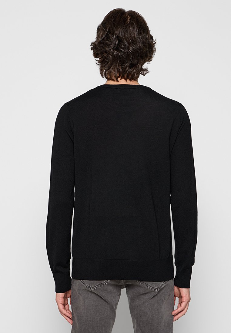 Schwarzer Strickpullover mit langen Ärmeln, rundem Halsausschnitt und gerippten Bündchen. Hat eine glatte Textur und eine figurbetonte Passform.