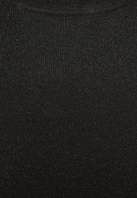 Czarna dzianina prążkowana o lekko teksturowanej powierzchni, zawierająca subtelne błyski w splocie, odpowiednia na dopasowany strój.