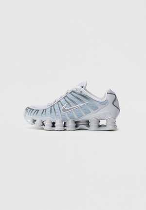 Ténis desportivos azul-claro com parte superior em malha, sola de borracha e amortecimento proeminente em forma de onda. Apresenta um logótipo prateado da Nike na lateral.