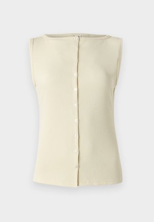 Haut sans manches beige clair en tissu côtelé, avec un col rond et un détail de boutons sur le devant. Texture lisse et design ajusté.