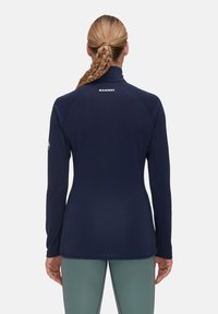 Maglione a maniche lunghe blu navy con colletto alto, tessuto elasticizzato e finitura testurizzata. Presenta il logo Mammt sul retro e un design aderente.