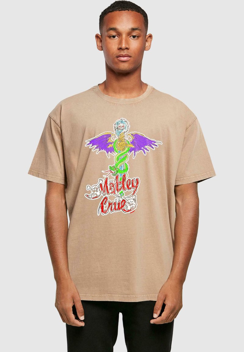 Beige kokvilnas T-krekls ar krāsainu, detalizētu pūķa grafiku ar purpura spārniem un tekstu "Motley Crue" sarkanā krāsā.