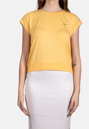 Žluté tričko s krátkým rukávem, kulatým výstřihem a přiléhavým lemem. Má hladkou texturu a malé logo na hrudi.