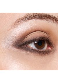 Close-up of an eye featuring a gradient eyeshadow, blending from light to dark brown, with thin eyelashes and well-groomed eyebrows.