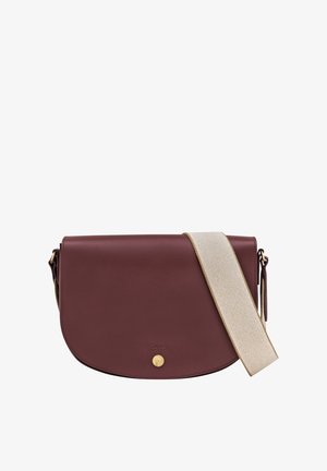 Burgundy leather crossbody bag with a rounded flap. Features a gold snap closure and a textured beige strap. Smooth surface with minimal detailing.