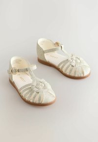 Glittery gold sandals with a T-strap design, woven front, and brown sole. Features a decorative buckle for secure fastening.