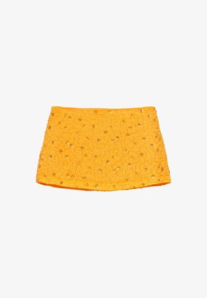 Mini-jupe jaune avec petites paillettes florales et ornements en perles sur le tissu, présentée sur fond blanc.