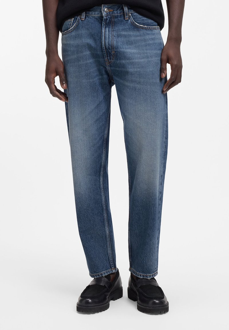 Blugi din denim albastru estompat, cu design cu picior drept, având un stil clasic cu cinci buzunare și detalii de cusături contrastante.