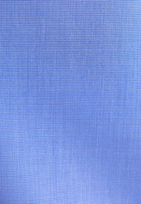 Gros plan d’un tissu bleu fin avec une texture lisse et serrée, et de petits fils espacés régulièrement.