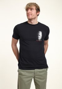 Czarny bawełniany t-shirt z nadrukiem grafiki czaszki oraz napisem "HELLRAISER" na czerwono, z okrągłym dekoltem i krótkimi rękawami.