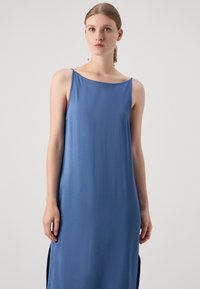 Rochie albastră fără mâneci cu un decolteu rotund, textură netedă și fante laterale, evidențiind un design minimalist.