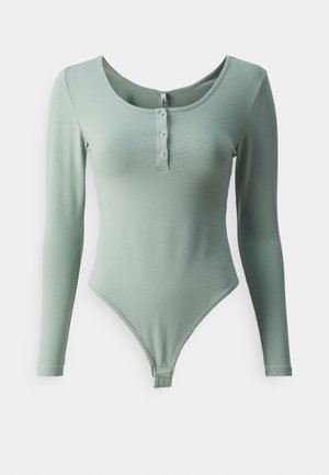 Hosszú ujjú bodysuit világoszöld színben, puha anyagból készült, mély kivágással és háromgombos záródással az elején.