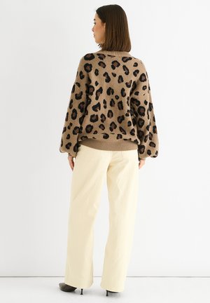 Brown leopard print sweater with a relaxed fit and balloon sleeves, paired with light beige wide-leg pants and grey heeled shoes.