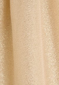 Tissu beige à armure texturée, avec des fils métalliques subtils créant un effet scintillant. Matière lisse et légère.