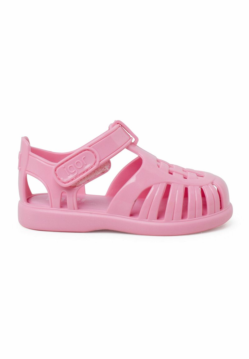 Roze plastic sandaal met een open ontwerp, voorzien van een klittenbandsluiting, een platte zool en uitsparingen in de bovenkant voor ademend vermogen.