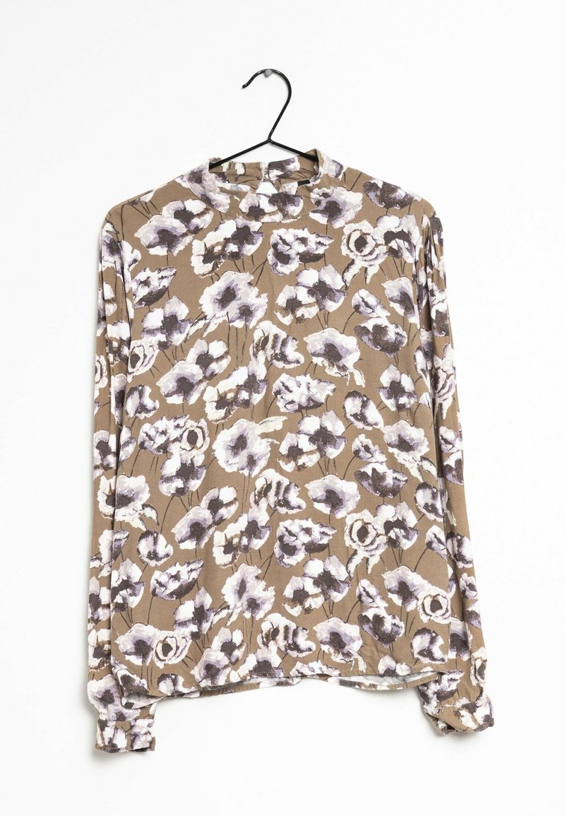 Blus med långa ärmar i mjukt tyg med en brun bakgrund och stora lila och vita blommönster. Rund halsringning och rak fåll.