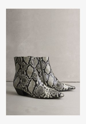Členkové čižmy s hadím vzorom, špicatou špičkou a nízkym blokovým podpätkom, s čierno-bielym textúrovaným vzorom a bočným zipsom.