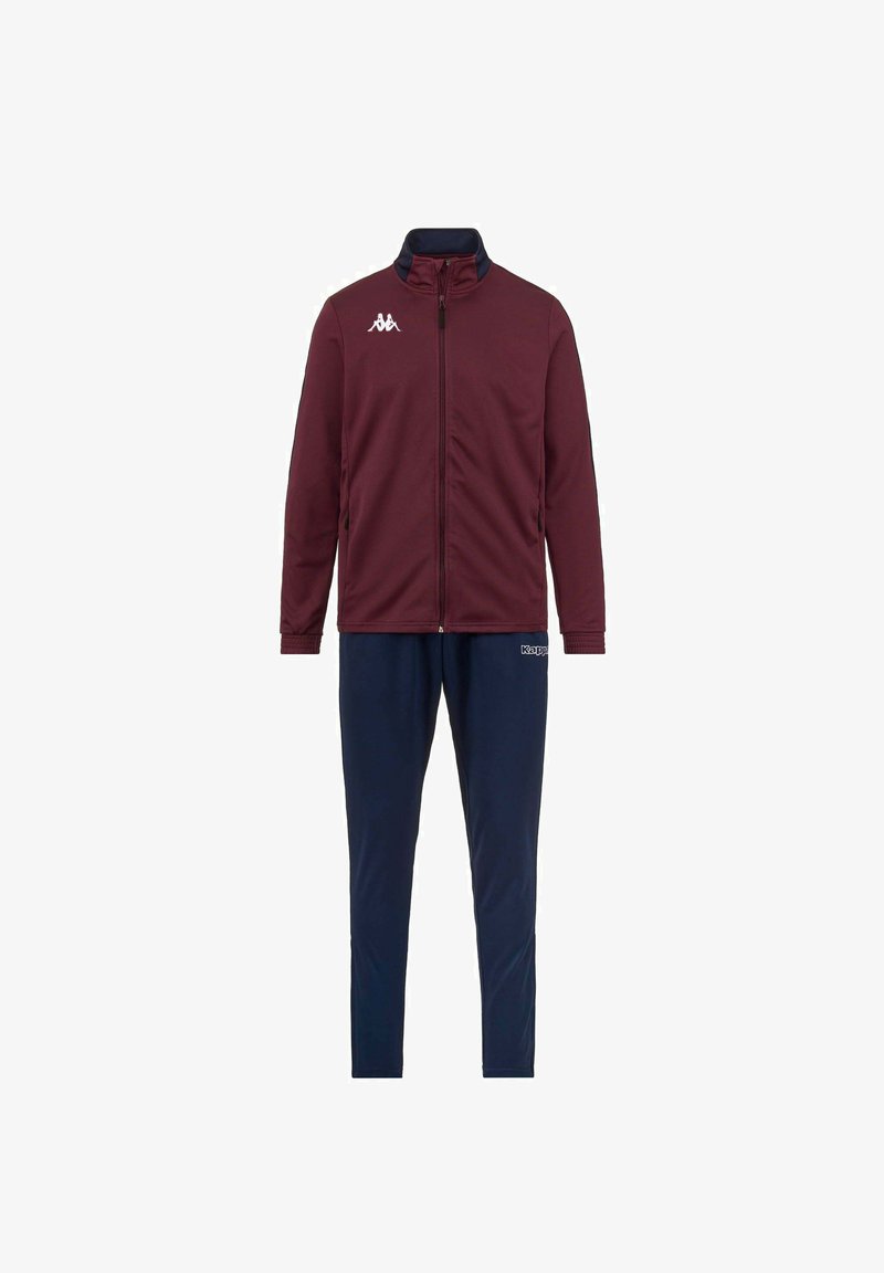 Giacca bordeaux con colletto alto e zip, abbinata a pantaloni blu navy. La giacca presenta un logo bianco sul petto, una vestibilità slim e una texture liscia.