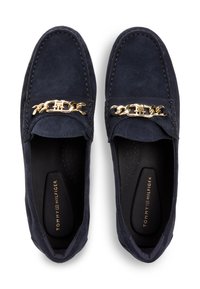 Μοκασίνια από σουέντ σε ναυτικό μπλε με διακοσμητική χρυσή αλυσίδα στο πάνω μέρος, με μαξιλαρωμένο πέλμα και διάτρητες λεπτομέρειες στο εσωτερικό.