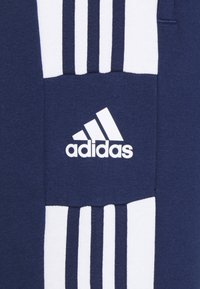 Marineblauwe sweatshirt met wit adidas-logo en drie witte strepen over de borst. Gemaakt van zachte, gestructureerde stof.