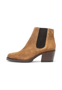 Bottines en daim marron avec un talon carré et un panneau élastique sur le côté. Design épuré avec une texture lisse et un matériel minimal.