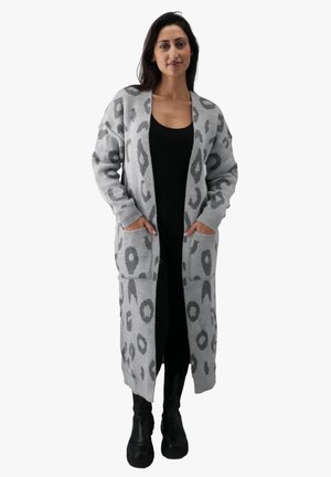 Lang grå cardigan med leopardprint, med ribmede manchetter og lommer, båret over en sort top og parret med sorte støvler.