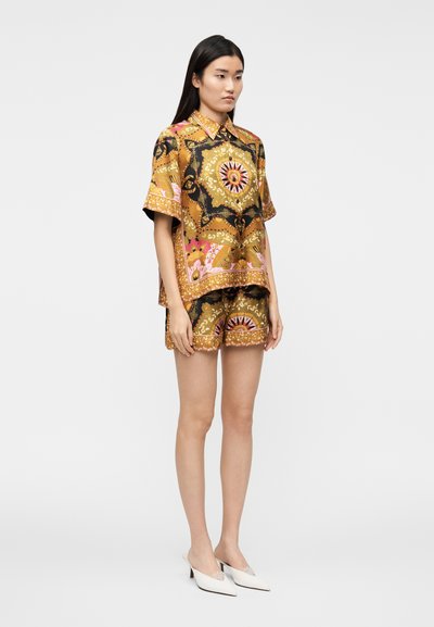 Short-sleeve, collared shirt and shorts set in gold with black floral patterns and pink accents; smooth fabric; relaxed fit.