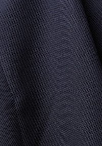 Tessuto di un blu navy scuro con una trama intrecciata, che mostra una finitura opaca e una leggera lucentezza in alcune aree. Ideale per rivestimenti o indumenti.