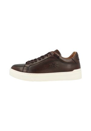 Mørkebrun læder lavtop sneaker med sorte snørebånd og hvid sål, der viser side logo og perforeringsdetaljer.