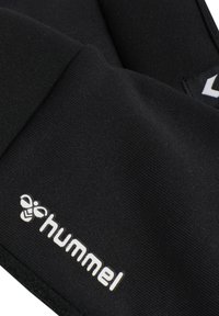 Gants de sport noirs en tissu texturé avec un logo "hummel" blanc bien visible. Comprend une fermeture ajustable au poignet pour un bon ajustement.